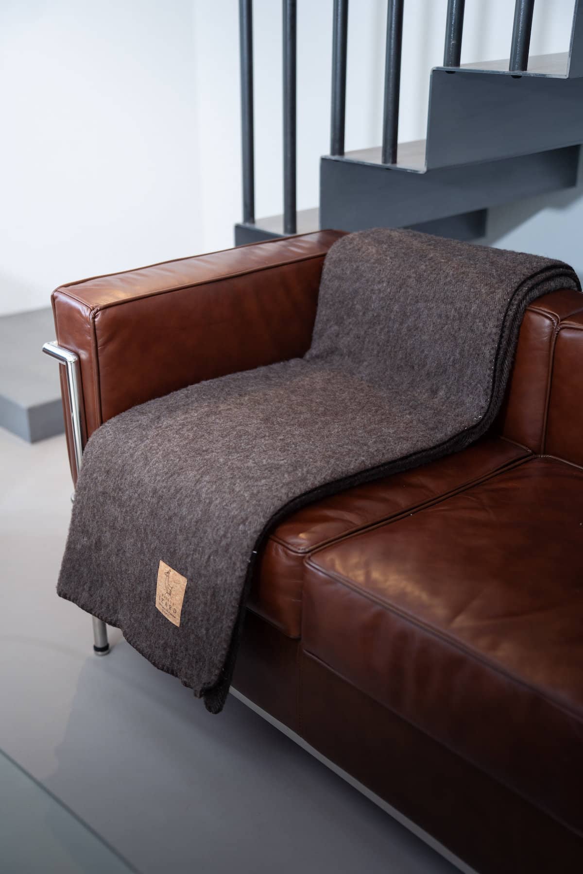 Plaid Calou marron en laine française posé sur un canapé